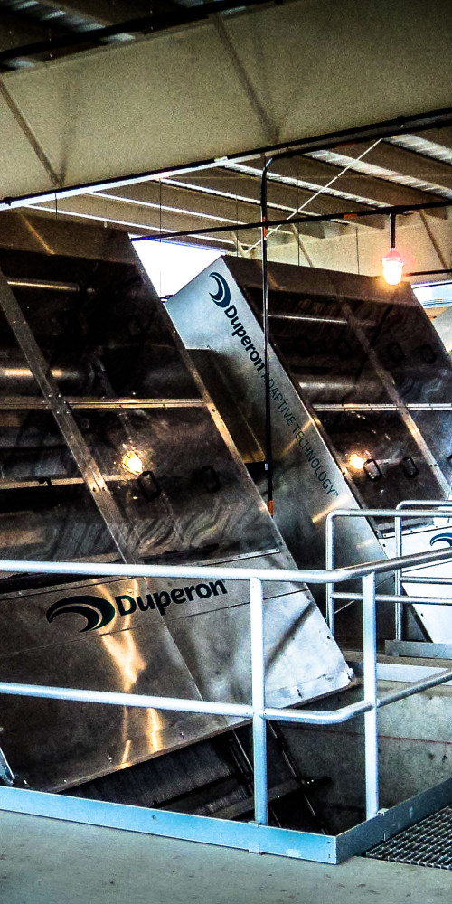 Three Duperon FlexRake bar screens installed in a covered headworks channel at a municipal wastewater treatment plant