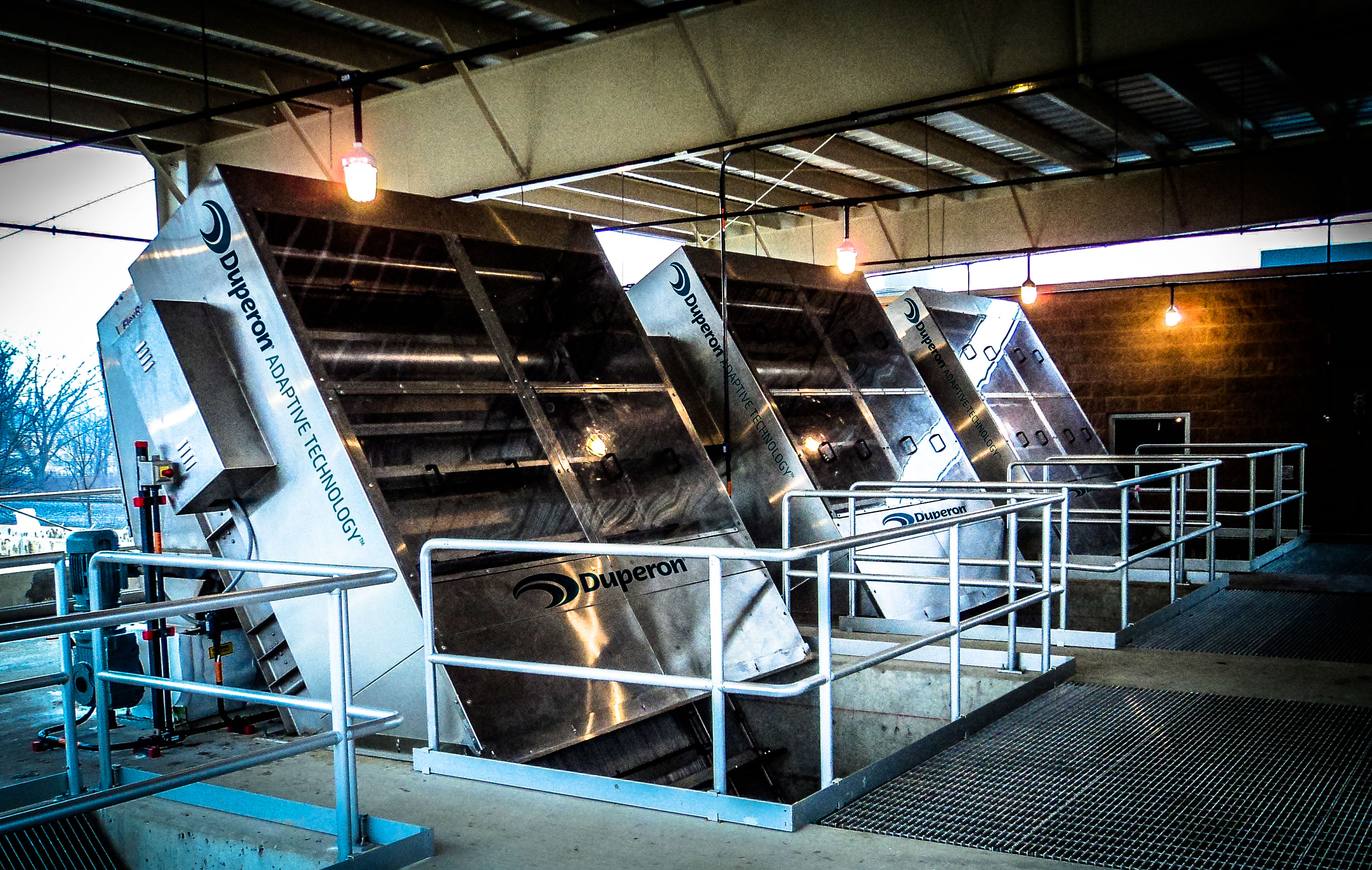 Three Duperon FlexRake bar screens installed in a covered headworks channel at a municipal wastewater treatment plant